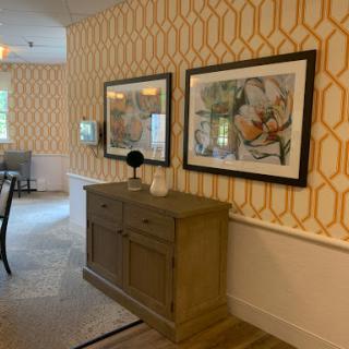 A stylish dining area featuring elegant wall art and a modern sideboard against a geometric patterned wall.