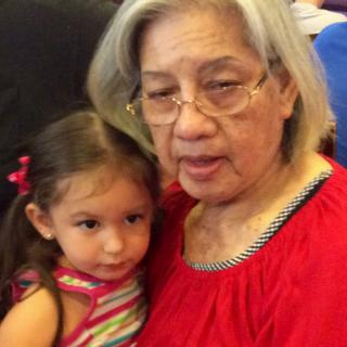 An elderly woman and a child cuddling together indoors.