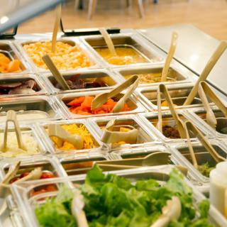 A diverse buffet featuring a selection of fresh vegetables and dishes at a salad bar.