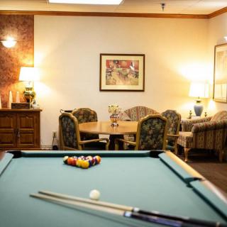 A cozy indoor game room featuring a pool table and comfortable seating area.