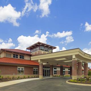A modern healthcare facility with a welcoming entrance under a bright blue sky.