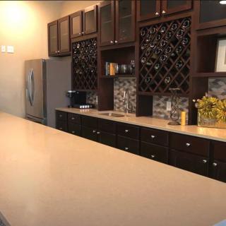 A modern kitchen with dark wood cabinets, a spacious countertop, and a built-in wine rack.