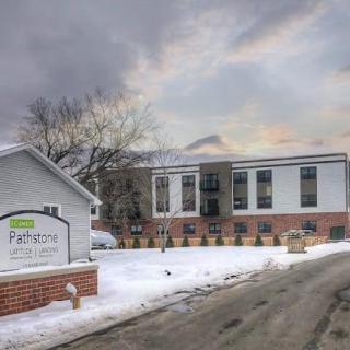 A view of a residential building surrounded by snow on a cloudy winter day.