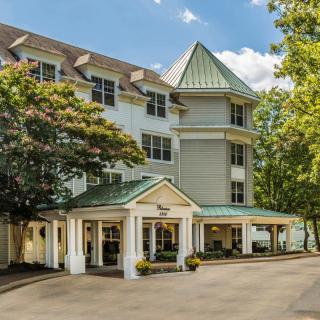 A charming hotel exterior with a welcoming entrance surrounded by trees.