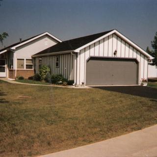 A suburban house with a two-car garage and a neatly maintained lawn.