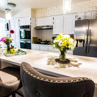 A modern kitchen with a central island adorned with flower arrangements and sleek appliances.