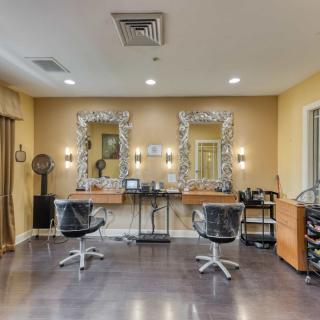 A well-lit salon interior with two workstations featuring mirrors and chairs.
