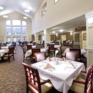 A spacious dining area with elegantly set tables and natural lighting.