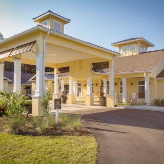 A welcoming residential building with a covered entryway and surrounding landscape.