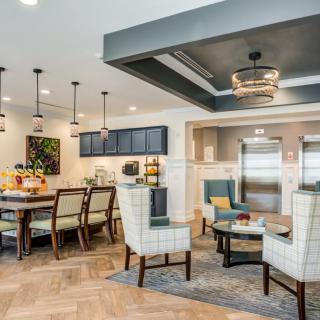 A modern open-concept living area featuring a dining and kitchen space with contemporary furniture and stylish lighting.
