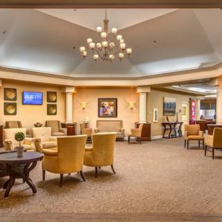 A spacious lobby with elegant seating and a central chandelier.