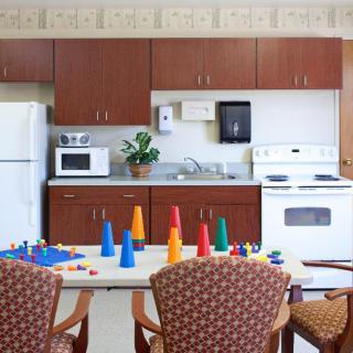 A kitchen area with cabinets, appliances, and a table set with colorful cones.