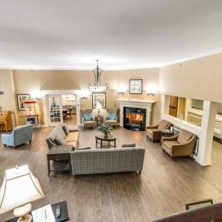 A cozy living room with a central seating area and a fireplace.