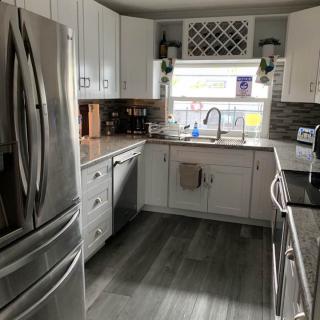 A modern kitchen with stainless steel appliances and white cabinetry.