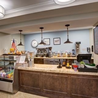 A cozy coffee shop interior with a counter displaying various beverages and snacks.
