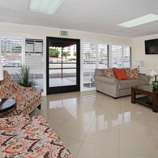 A modern living room with patterned sofas, a coffee table, and a flat-screen TV.
