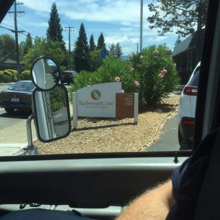 View from inside a vehicle approaching a drive-thru with visible signage.