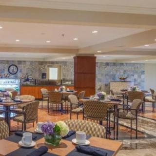 A spacious and elegantly decorated restaurant dining area with neatly arranged tables and chairs.