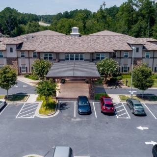 Aerial view of a suburban building with a parking lot in the foreground.