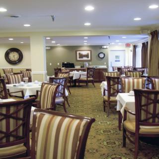 An empty restaurant dining room with neatly arranged tables and chairs.