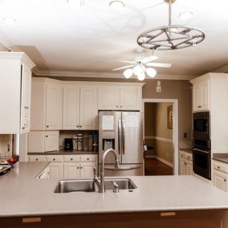 A modern kitchen with white cabinets and stainless steel appliances.