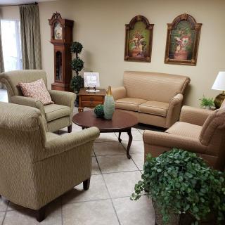 A traditional living room setup with sofas, armchairs, a coffee table, and decorative elements.