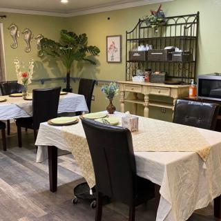 A cozy dining area with multiple tables and chairs, adorned with tablecloths and decorations.