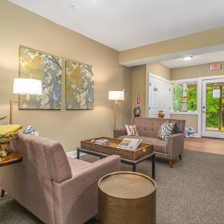 A cozy living room with comfortable seating, artwork, and soft lighting.
