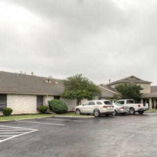 A parking lot in front of a building on a cloudy day.