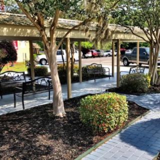 Outdoor patio area with seating, trees, and paved paths.