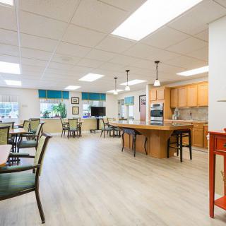 A spacious and modern kitchen with a dining area, featuring wood flooring and ample natural light.