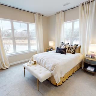 A modern and cozy bedroom with large windows, elegant curtains, and stylish decor.