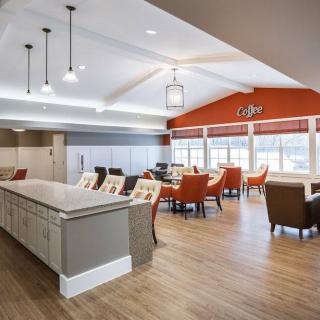 A modern cafe interior with a spacious seating area and stylish lighting.