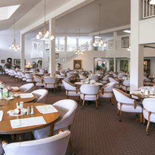 A spacious and elegantly designed restaurant dining area with neatly arranged tables and chairs.