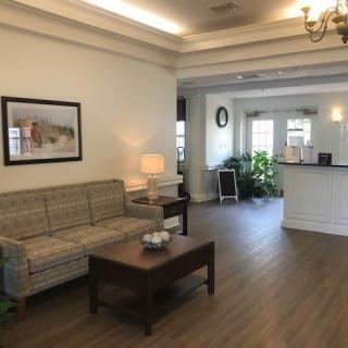 A cozy living room with a sofa, coffee table, and elegant decor near a reception area.