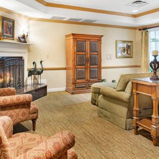 A cozy living room with a fireplace, comfortable seating, and elegant decor.