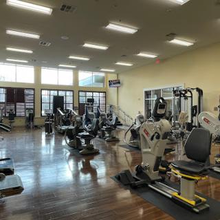 A spacious gym filled with various exercise equipment, designed for fitness enthusiasts.