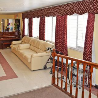 A cozy living room with a beige sofa, elegant red curtains, and a decorative mirror.