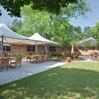 A serene outdoor space featuring a landscaped garden, seating arrangements, and stylish canopies.