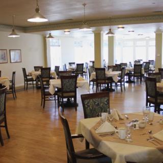 An empty dining room with neatly set tables and chairs arranged in a spacious layout.