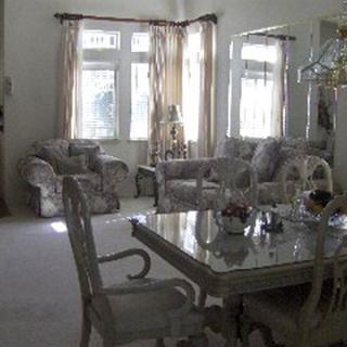 A cozy living room and dining area with elegant furnishings and large windows.