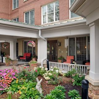 A charming courtyard garden with colorful flowers and a cozy patio area.