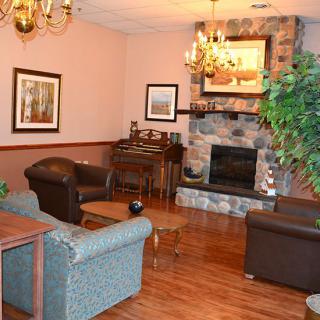 A cozy living room with a stone fireplace, comfortable seating, and elegant decor.