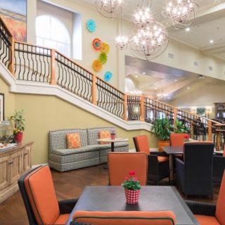 A spacious and inviting lobby with elegant chandeliers, comfortable seating, and a decorative staircase.