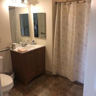 A clean bathroom with a sink, mirror, and shower curtain.