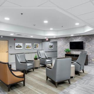 A modern waiting room with comfortable seating and a television.