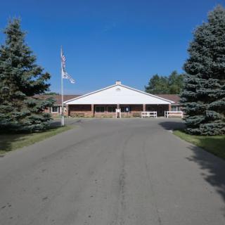 A well-maintained building surrounded by trees, showcasing a clear blue sky.