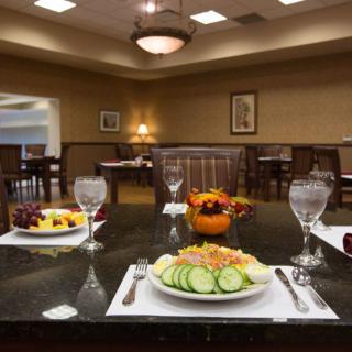 An elegantly set dining table in a restaurant with plates of food and glasses of water.