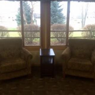 A cozy seating area with two chairs and a side table by the window.
