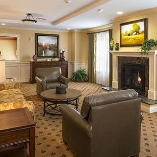 A cozy living room featuring a fireplace, comfortable seating, and elegant artwork.